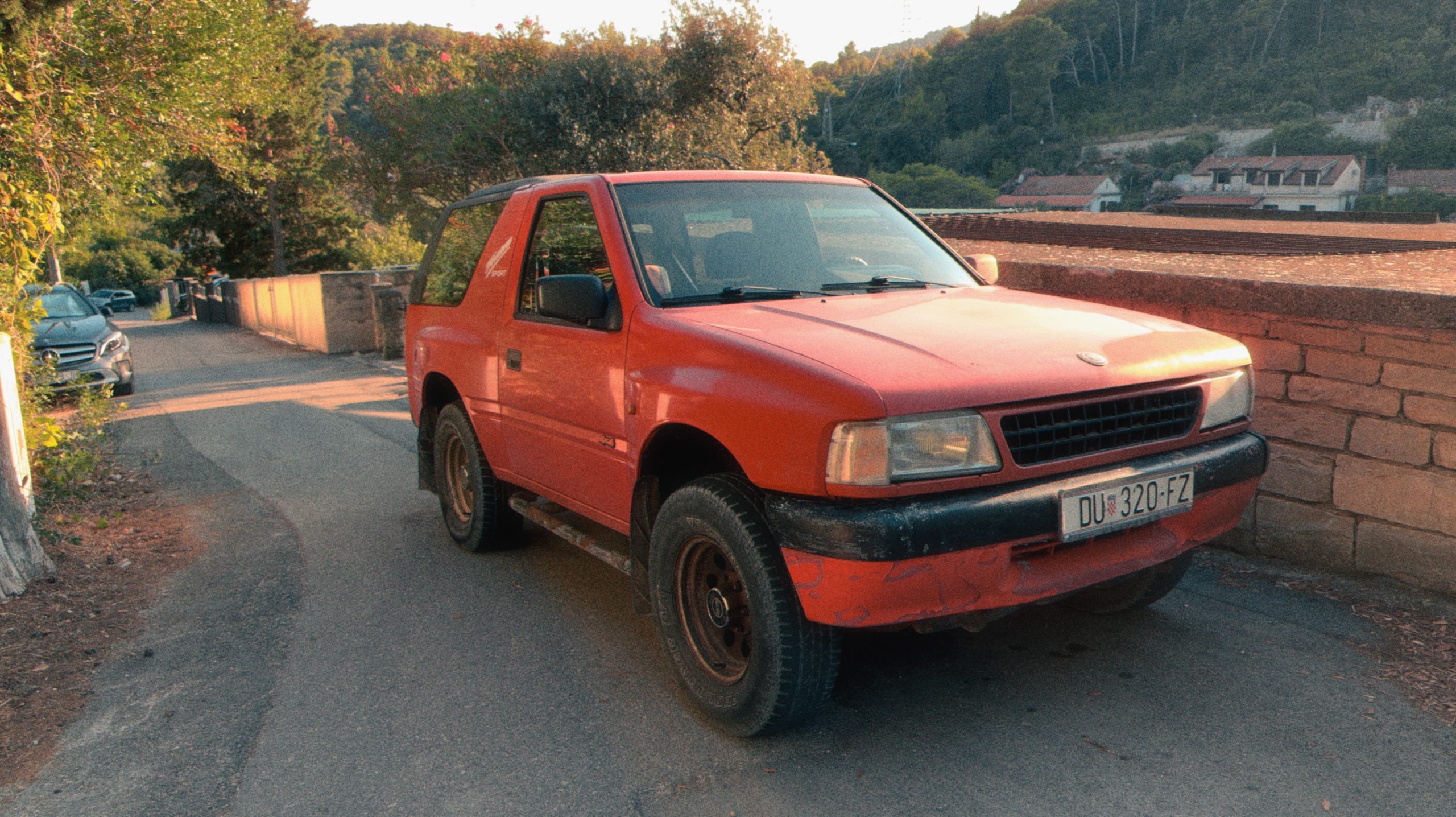 A bright red Opel Frontera Sport parked on Korčula island. 